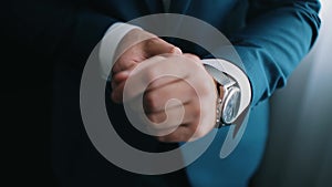 Close-up of a successful man is putting on a watch. Men`s hand with a watch. Wedding day.