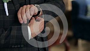 Close-up of a successful man is putting on a wristwatch.