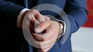 Close-up of a successful man is putting on a wristwatch, watch on a man`s hand.