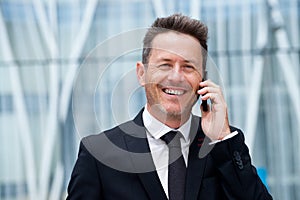 Close up successful older businessman talking on mobile phone