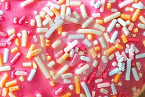 Sugar sprinkled pink donut glace, close up picture