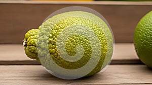 Close-up of a SumoS Citrus fruit with distinct textured rind on a wooden surface creating a