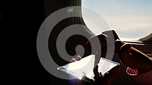 Close-up. the sun`s rays are reflected in the phone. dark silhouette of kid hands and mobile phone against airplane`s