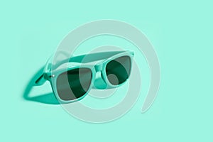 Close-up of sunglasses on background of aqua menthe color.