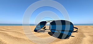 close up sunglasses on the sandy beach