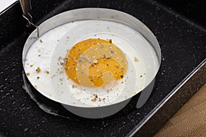 Close-up of sunny side up eggs in a frying pan for breakfast on wooden table background