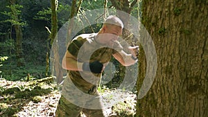 close-up, super slow motion. male boxer training in the forest, boxing the trunk of a large tree