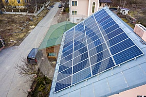 Close-up surface of lit by sun blue shiny solar photo voltaic panels system on building roof. Renewable ecological green energy