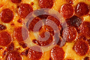 Close-up of the surface of pepperoni pizza with sausages and mozzarella