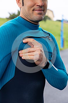 Close-up of surfer adjusting wetsuit, vertical photo