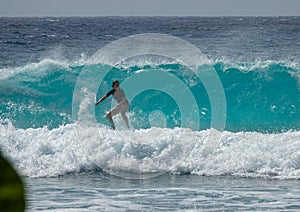 CLOSE UP: Surfer rides a big glassy wave breaking towards a tropical island