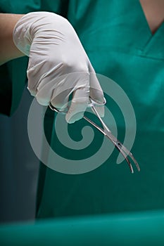 Close-up of a surgeon's hand with surgical scissors