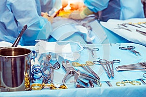 Close up surgical instruments and tools including scalpels, forceps and tweezers arranged on a table for a surgery. Selective focu