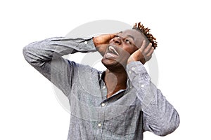 Close up surprised young african man screaming against white wall with hands on face