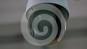 Close-up of surveillance video camera rotating around.