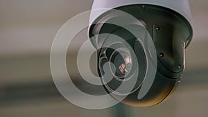 Close-up of surveillance video camera rotating around.