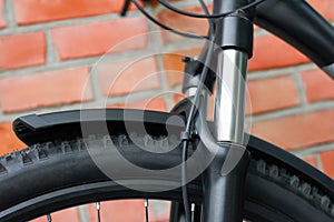 Close-up of the suspension fork of the front wheel of a bicycle. Outdoors