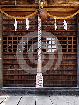 Close-up of Suzu Japanese Shinto bell and the rope hanging under the eaves