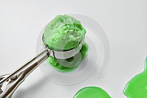 Close-up of sweet appetizing ice cream in a metal scoop on a gray background with copy space.