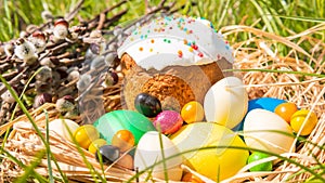 Close-up of sweet Easter cakes with colorful eggs among spring grass