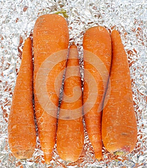 close up of sweet orange carrots over a tin paper