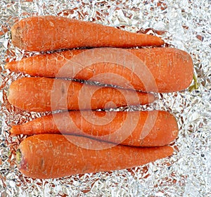 close up of sweet orange carrots over a tin paper