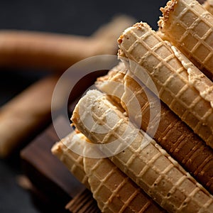 Close up of Sweet rolls filled or stuffed with condensed milk. Wafer rolls or tubes on blurred background. Soft focus