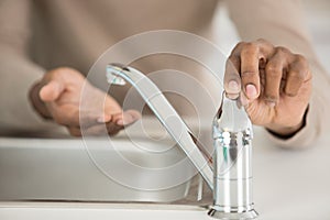 close-up switching on tap to wash hands