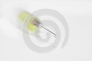 Close-up of syringe with needle drop