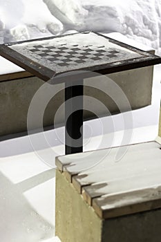 close-up table with a chessboard covered with snow