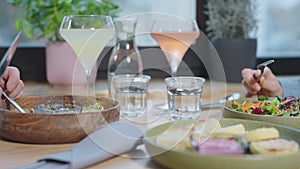 Close-up of a table with food in a cafe. Unrecognizable man and woman in a restaurant, lunch with various vegetarian