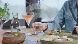 Close-up of a table with food in a cafe. Unrecognizable man and woman in a restaurant, lunch with various vegetarian