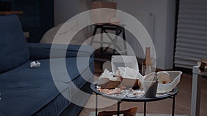 Close up of table with leftover on it in empty unorganized messy living room