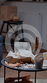 Close up of table with leftover on it in empty unorganized messy living room