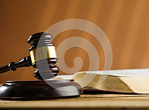 Close-up. On the table is an open book and a judge`s wooden gavel. Symbols of a fair trial. Rule of law, Constitution, democracy.