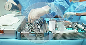 Close up of table with sterilization containers with sterilized tools Second plan slightly blurred - male veterinarian