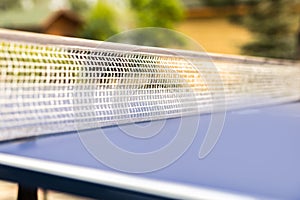 Close-up table tennis net. Ping pong equipment outdoors. Family sport activity
