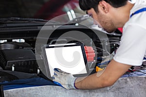 Close up Tablet empty white screen, Repairman auto mechanic using tablet white screen to check for damage inside engine.