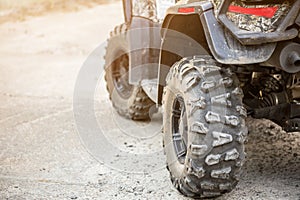 Close-up tail view of ATV quad bike. Dirty whell of AWD all-terrain vehicle. Travel and adventure concept.Copyspace.Toned