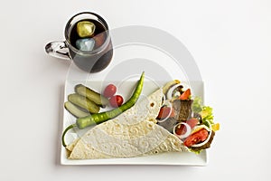 Delicious Turkish kebab doner wrapped with flat bread lavasin the white long plate