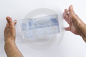 Hand is holding of three ply structure,single use hygenic face mask on white background photo