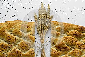 Close-up taken of Ramadan Bread,Pide cut in half on white with natural wheat ears.