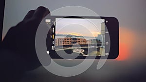 Close up of taking pictures of city with blurred architectures on sunset background. 1920x1080