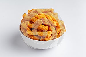 Close up of tangy Potato Puff Snacks sticks, Popular Ready to eat crunchy and puffed snacks sticks tangy spicy  orange color over