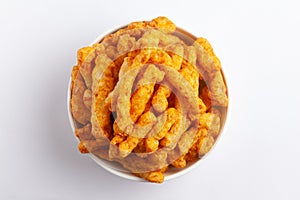 Close up of tangy Potato Puff Snacks sticks, Popular Ready to eat crunchy and puffed snacks sticks tangy spicy  orange color over