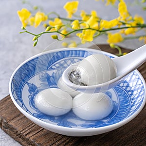 Close up of tangyuan in a bowl on gray table, food for Winter Solstice