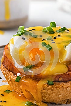 Close up of tasty egg benedict with poached egg, ham and hollandaise sauce. close up. vertical orientation