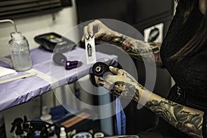 Close up tattooer hands changing tattoo machinery needle