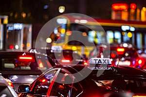 Close-up of a taxi in a traffic jam in the center of big city at night