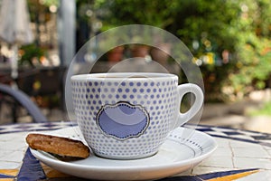 Close-Up of a tea cup with a Buscuit